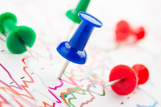 Close-up of red, blue and green pins on graphic