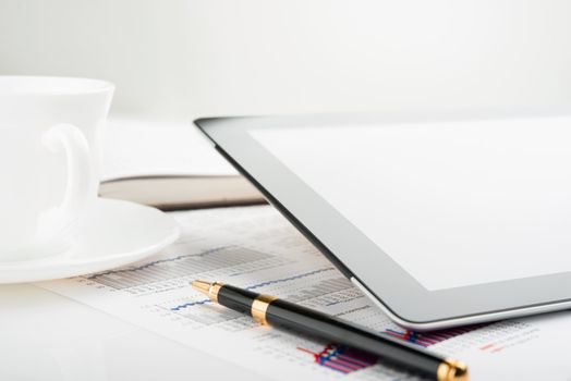Tablet computer with blank screen on a businessman workplace