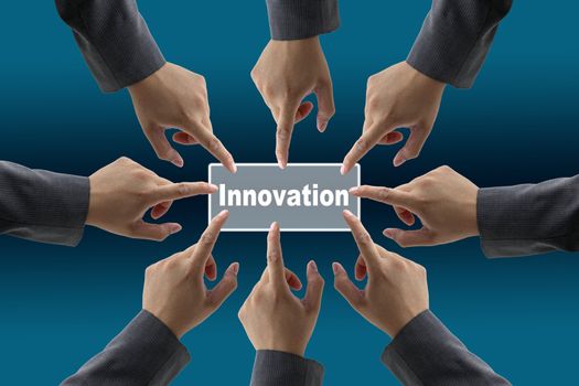 A diverse business team with hands together push Innovation button
