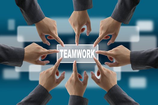 A diverse business team with hands together push teamwork button