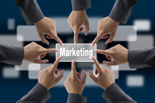 A diverse business team with hands together push Marketing button