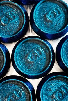 Overhead view of cold cola cans backlit