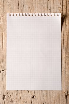 One notepad sheet torn out on a wood