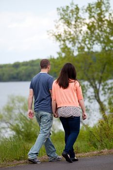 Young happy couple enjoying each others company outdoors walking down the side of the street.