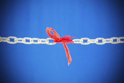 Broken chain connected with red threads 