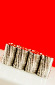 Coins stacked in bars against red background