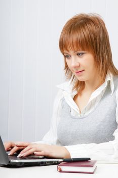 girl in office looking at laptop. Office