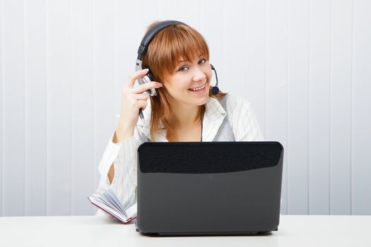 girl in headphones with a microphone and a laptop
