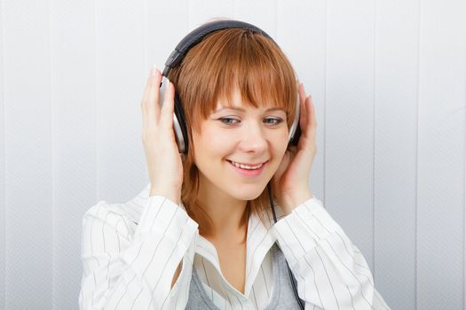 The girl in headphones listens to music with pleasure