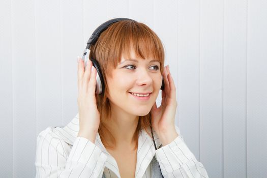 The girl in headphones listens to music with pleasure