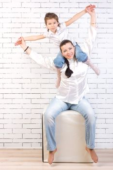 5 year old girl in jeans sitting on the neck of his mother