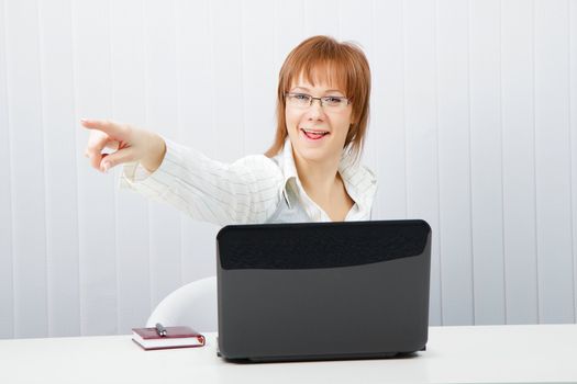 funny employee office. Woman with laptop points a finger in the direction of