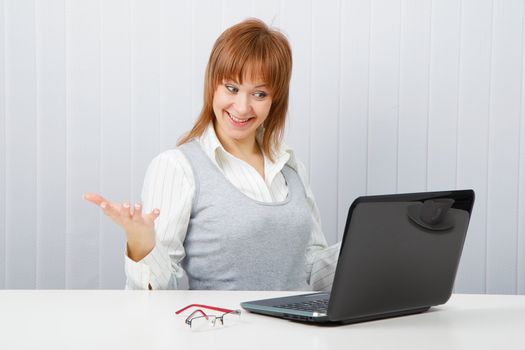 Delighted girl looks at a monitor. Office