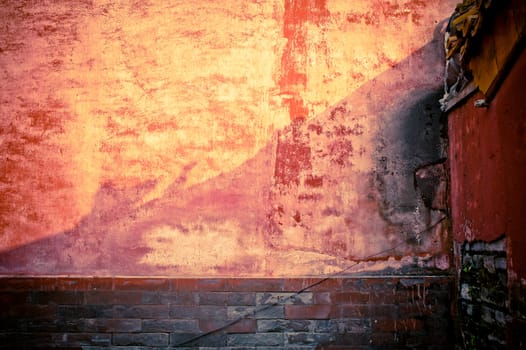 A weathered stone wall, in red tint.