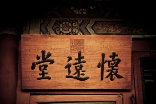 Wood plaque with Chinese writing. The sign contains a generic Chinese proverb, and is not a trademark.