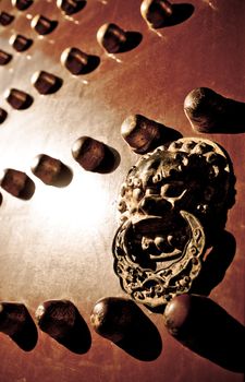 Lion door handle on a red door in the Imperial Palace.