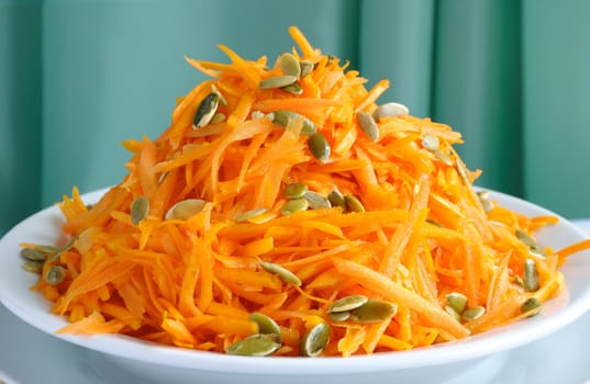 Salad of fresh pumpkin and carrot with pumpkin seeds