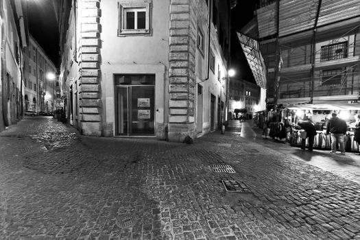 An empty and deserted cobble stone streets of Rome at night.