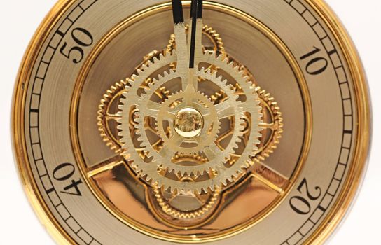closeup golden clock with gears on white