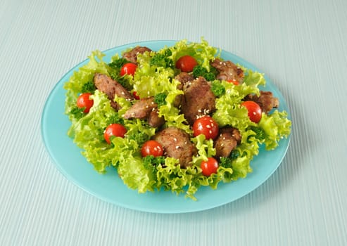 Salad of lettuce with cherry tomatoes and sesame seeds with chicken liver