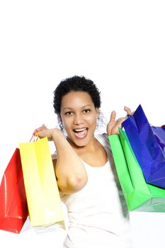 Laughing attractive African American woman carrying colourful shopping bags over her shoulders isolated on white
