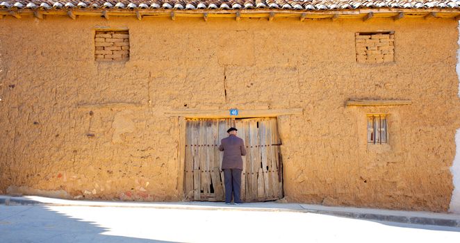 Old man closing the door of poor house