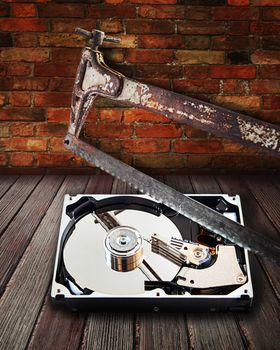 Hard disk cut with a hacksaw on boards against a brick wall