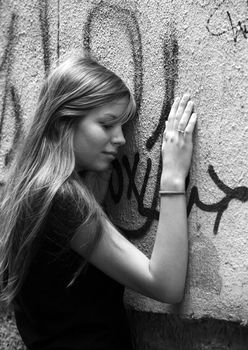 The young girl with phone on a background of a wall with graffiti