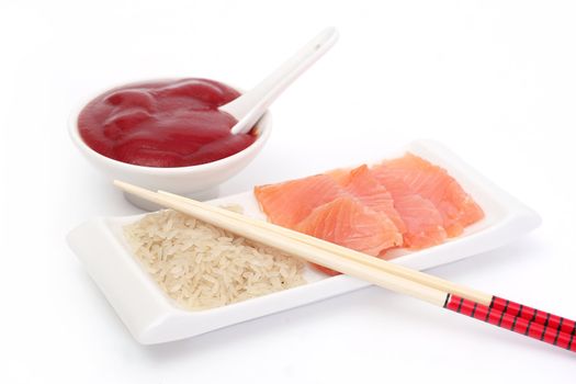 Chinese chopsticks and plate with rice, a red fish and sauce