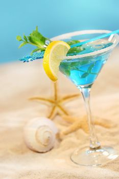 Blue tropical summer drink in the sand