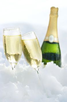 Champagne glasses and bottle in the snow