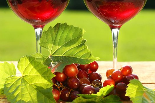 Glasses of  red wine with grapes on a table