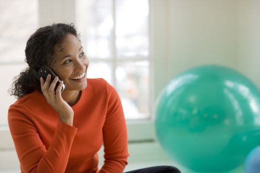 Smiling beautiful African American woman talking on a cell phone
