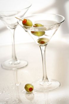 Martinis with green olives on bar counter