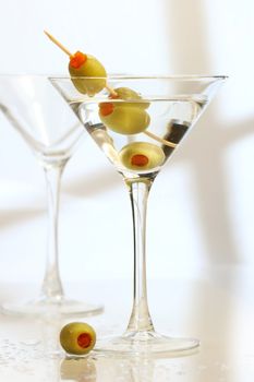Martini with 3 olives on bar counter
