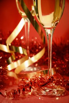 
Fluted champagne glasses and ribbons on red background