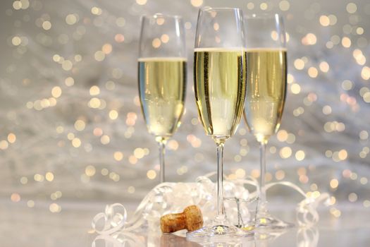 Threes glasses of champagne with silver background