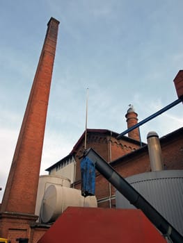Exterior of a brewery with a high chimney