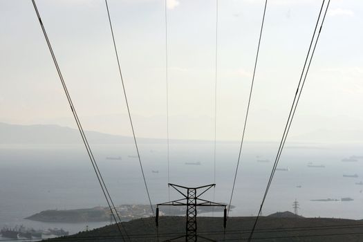 prespective dark electric cables and view of sea and ships in the afternoon at piraeus greece