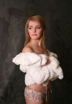 Portrait of the fine woman in underwear and a fur coat
