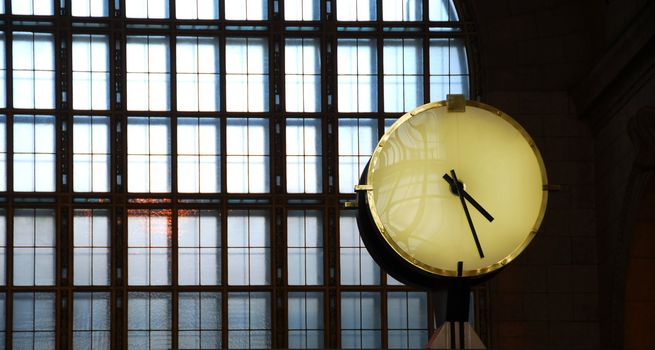 Big clock inside a train station with big window