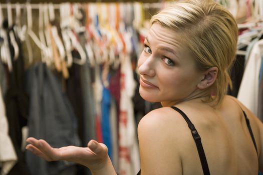 Attractive woman searching for clothes in closet