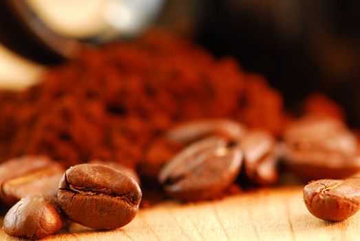 Macro image of coffee beans and ground coffee with black coffee cup