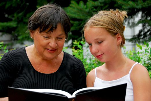 Grandmother and granddaughter reading a book