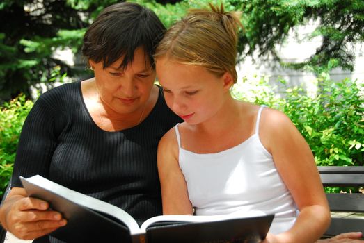 Grandmother and granddaughter reading a book