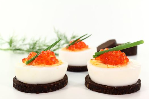 Canapes with boiled egg, chives and caviar