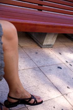 leg of a woman sitting on a bench