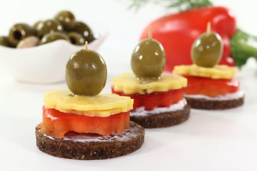 Canapes with cheese, red peppers and olives