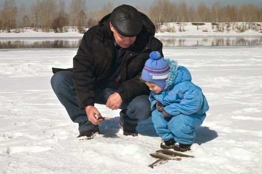 The boy, the child with the father  on winter fishing