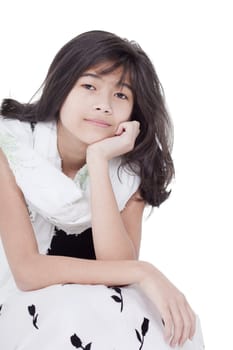 Young biracial asian girl in bkack and white formal dress, sitting and smiling, chin on hand